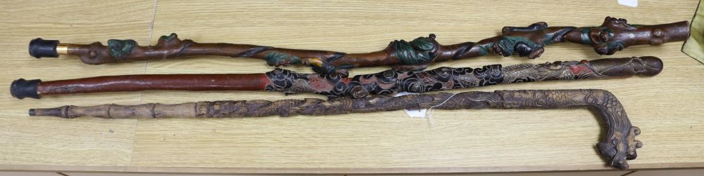 Three Chinese carved wood walking sticks, largest 108cm
